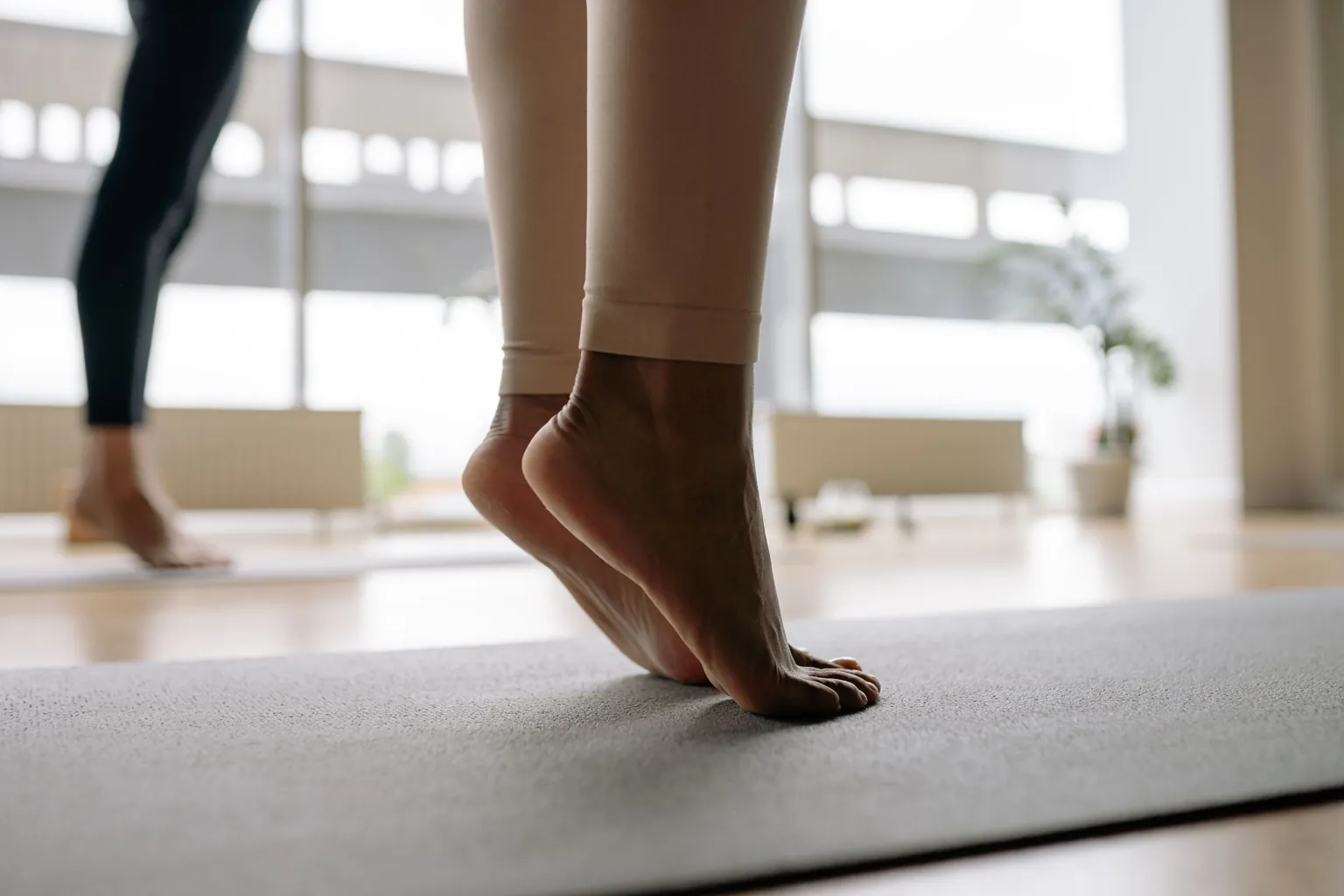 Pieds nus montés sur la pointe sur un tapis d'exercice, talons décollés du sol